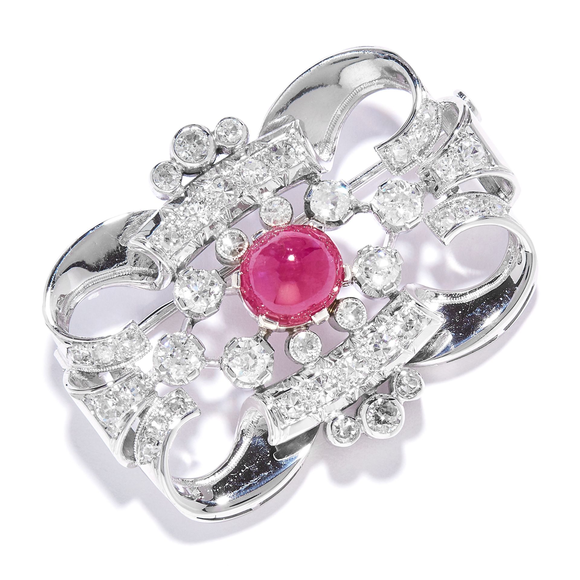 A RUBY AND DIAMOND BROOCH in 14ct white gold, in scrolling motif, set with a cabochon ruby and old