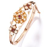 ANTIQUE PEARL AND RUBY BANGLE in 18ct yellow gold, the split, openwork design set with ruby and