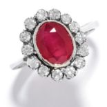 RUBY AND DIAMOND CLUSTER RING in white gold, set with an oval cut ruby in a cluster of round cut