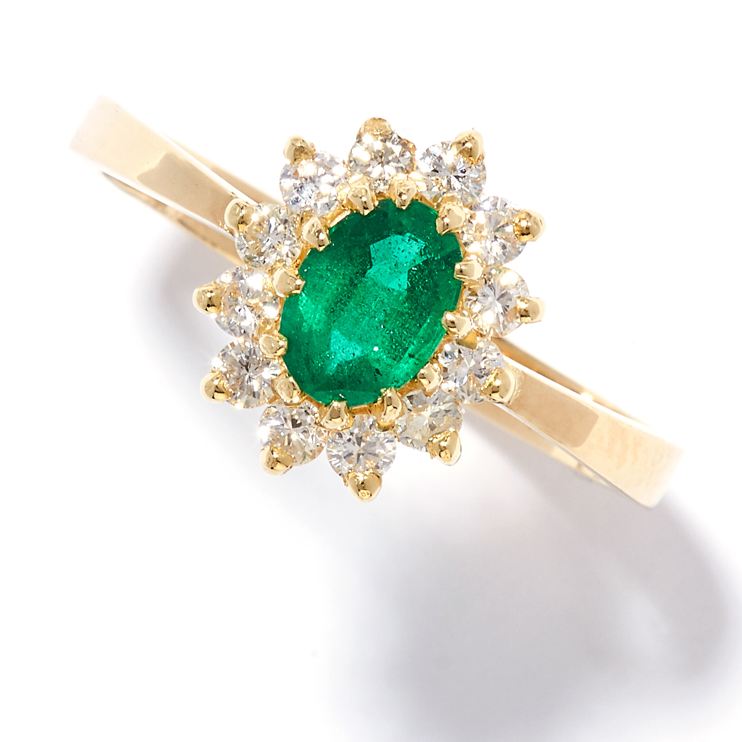 AN EMERALD AND DIAMOND RING in 18ct yellow gold, the oval cut emerald set within a border of round