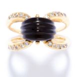 ONYX AND DIAMOND DRESS RING in 18ct yellow gold, set with a carved onyx between bifurcated border