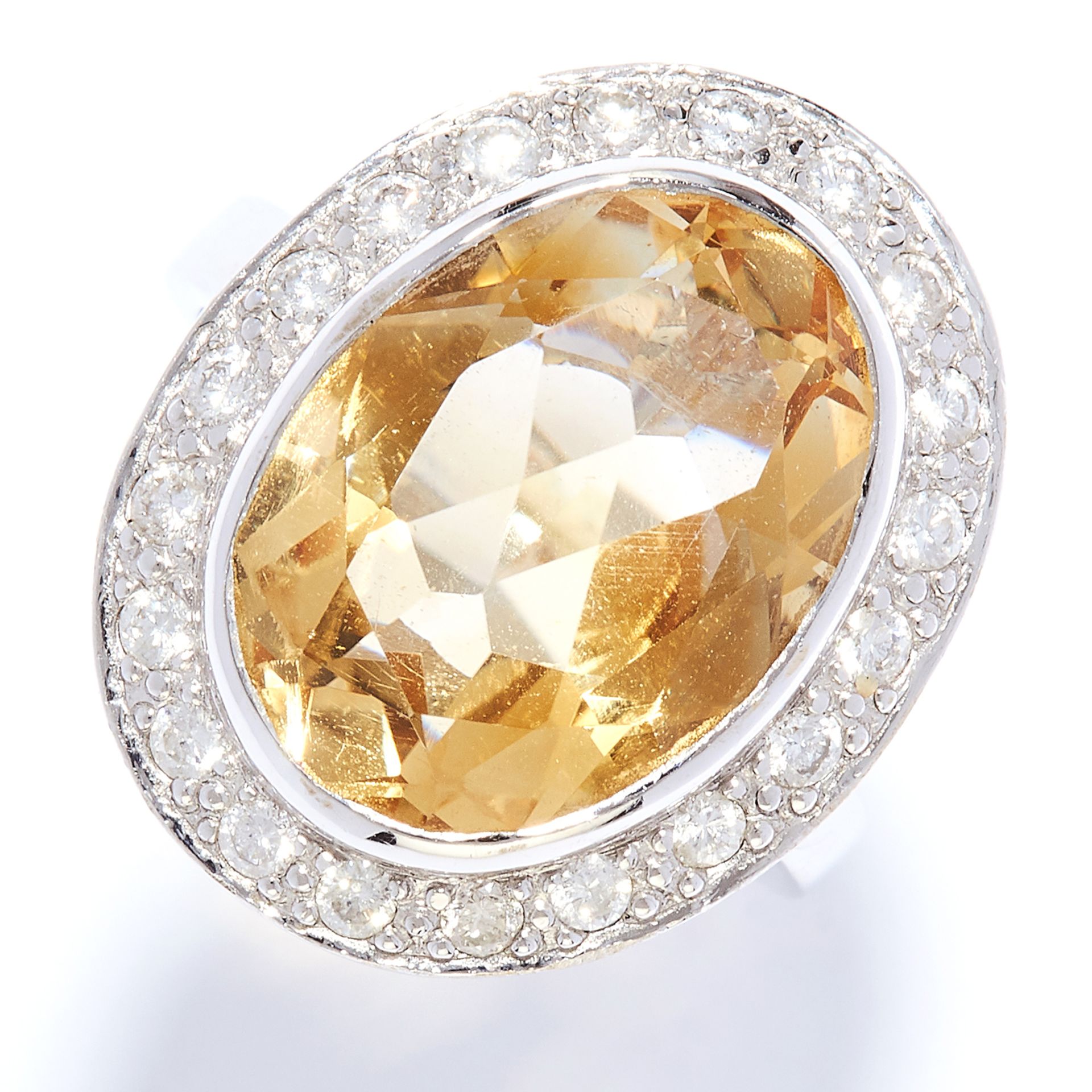 CITRINE AND DIAMOND CLUSTER RING in 18ct white gold, set with an oval cut citrine in a border of