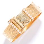 ANTIQUE PEARL BANGLE in high carat yellow gold, in buckle motif set with seed pearls and engraved