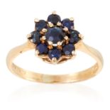 A SAPPHIRE CLUSTER RING in yellow gold, set with round cut sapphires in cluster form, British