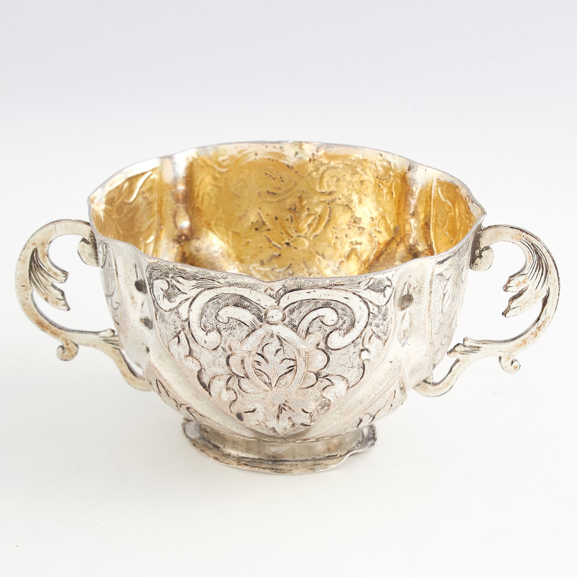 ANTIQUE GERMAN SILVER PORRINGER of rounded form with chased foliate scroll decoration, twin