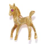 RUBY HORSE BROOCH, CARTIER in 18ct yellow gold, depicting a horse with a round cut ruby eye,
