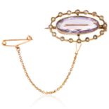 ANTIQUE AMETHYST AND PEARL BROOCH in yellow gold, set with an oval cut amethyst and seed pearls,