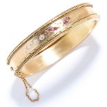 ANTIQUE RUBY AND DIAMOND BANGLE in yellow gold, set with round cut rubies and diamonds in engraved