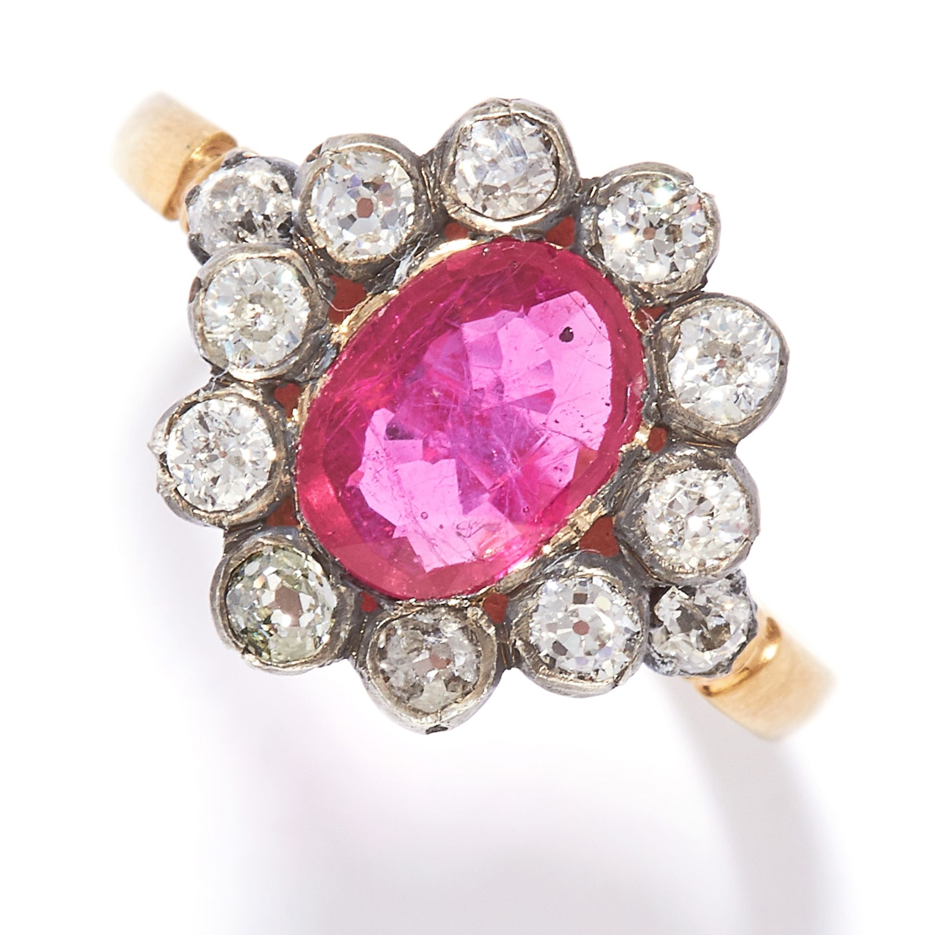 RUBY AND DIAMOND CLUSTER RING in yellow gold, set with an oval cut ruby in a cluster of round cut