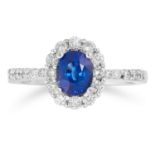 A SAPPHIRE AND WHITE GEMSTONE CLUSTER RING set with a central cushion cut sapphire in a border or