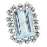 AN AQUAMARINE AND DIAMOND RING set with an emerald cut aquamarine in a border of round cut diamonds,