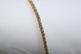 AN 18CT YELLOW GOLD AND DIAMOND LINE BRACELET