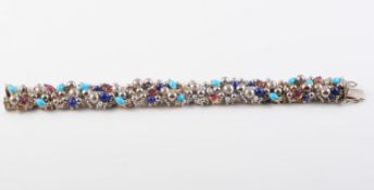 AN 18CT WHITE GOLD, NATURAL RUBY, TURQUOISE AND LAPIS LAZULI BRACELET BY STUART DEVLIN