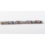 AN 18CT WHITE GOLD, NATURAL RUBY, TURQUOISE AND LAPIS LAZULI BRACELET BY STUART DEVLIN