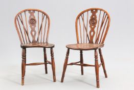A PAIR OF EARLY 19TH CENTURY YEW AND ELM WHEELBACK WINDSOR CHAIRS
