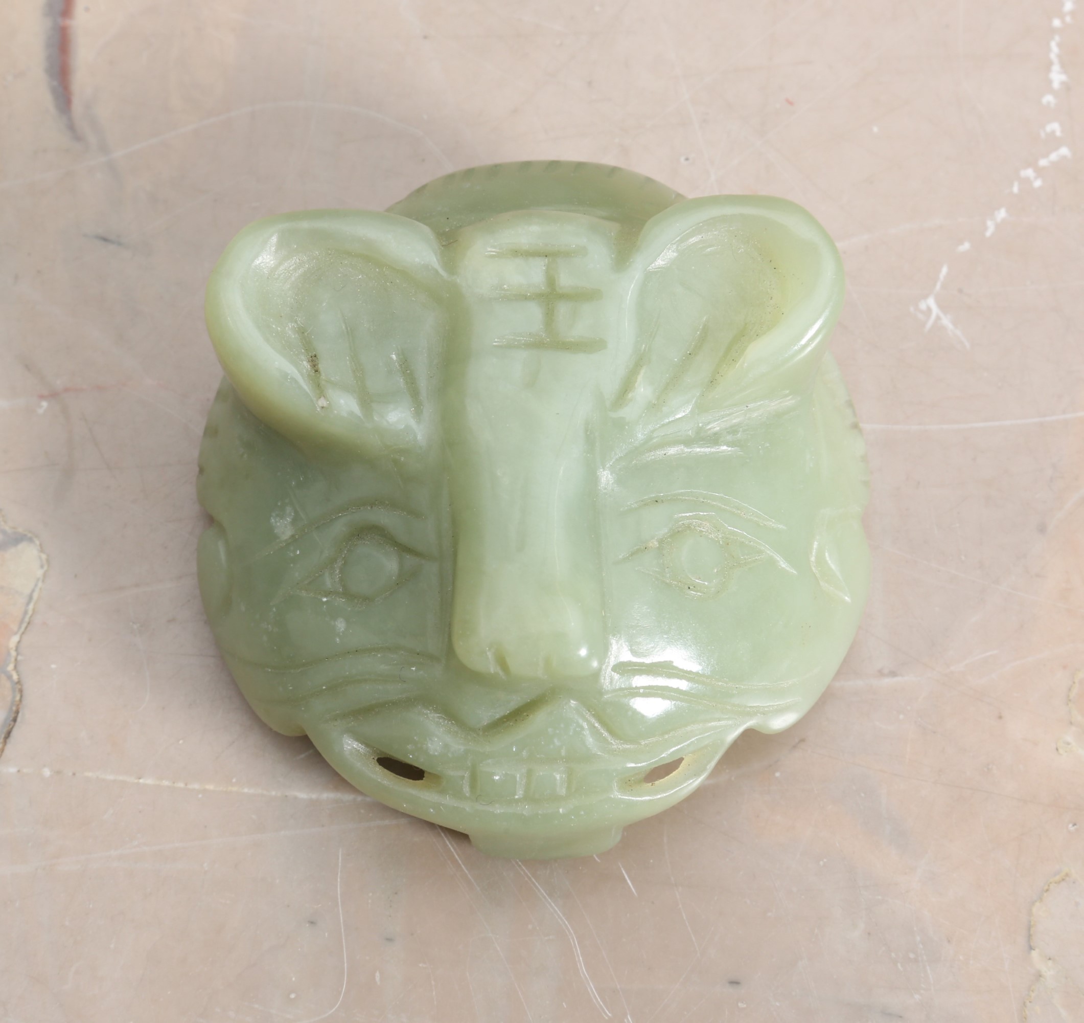 A CHINESE CARVED GREEN HARDSTONE BUCKLE