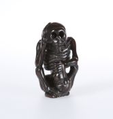 A JAPANESE WOODEN NETSUKE OF A SKELETON