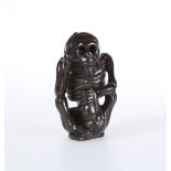 A JAPANESE WOODEN NETSUKE OF A SKELETON