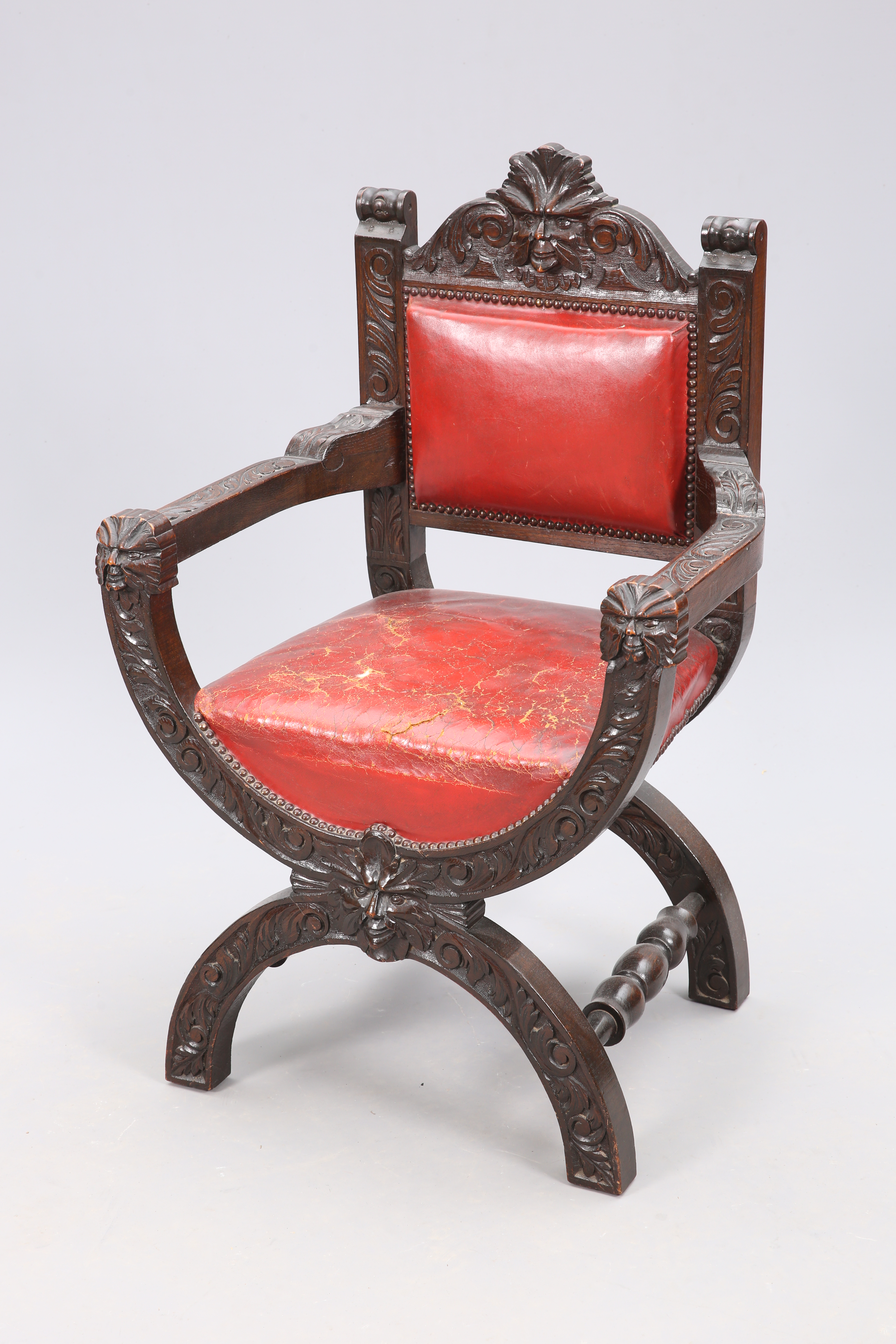 A LATE VICTORIAN CARVED OAK SAVONAROLA CHAIR