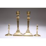 TWO PAIRS OF BRASS CANDLESTICKS