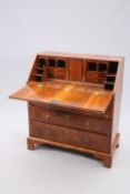 A GEORGE II FEATHER BANDED WALNUT BUREAU