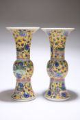 A PAIR OF CHINESE FAMILLE ROSE YELLOW GROUND PORCELAIN GU VASES