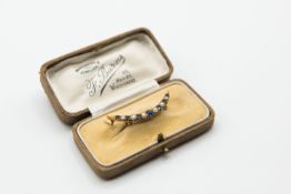 A LATE 19TH CENTURY SAPPHIRE AND SEED PEARL CRESCENT BROOCH