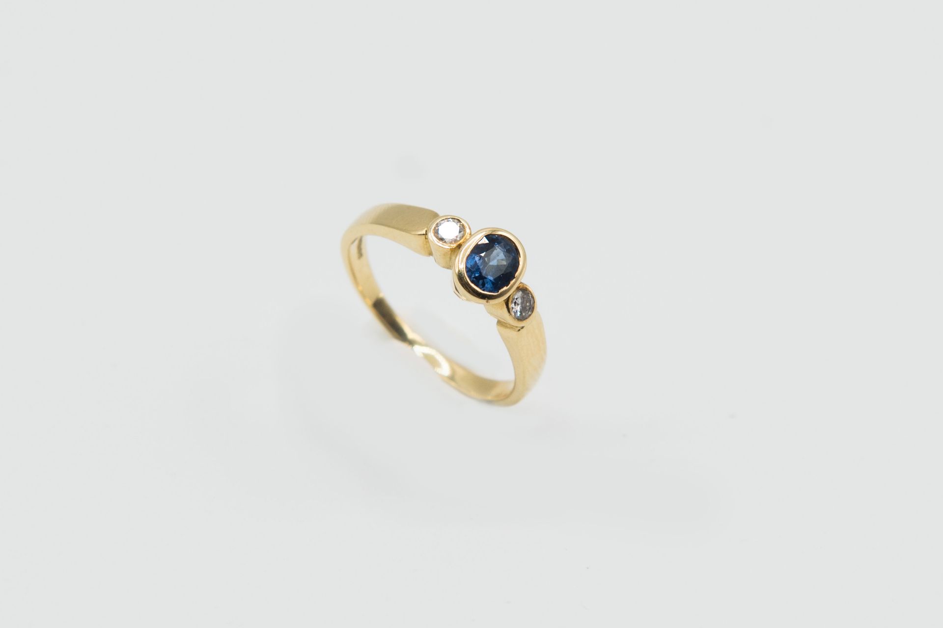 A SAPPHIRE, DIAMOND AND YELLOW GOLD RING