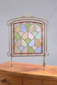 AN EARLY 20TH CENTURY BRASS, LEADED AND STAINED GLASS FIRESCREEN