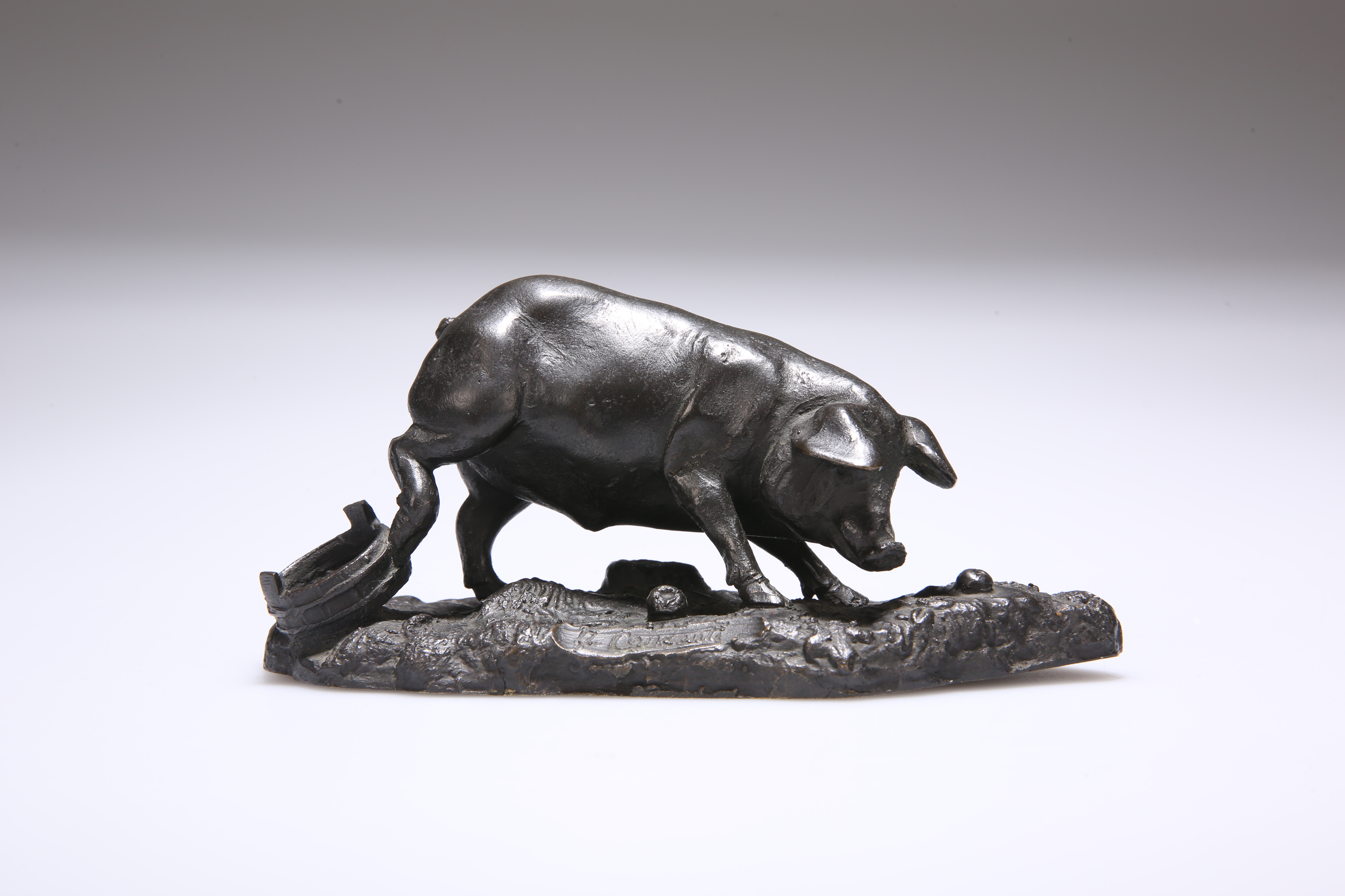 A BRONZE MODEL OF A PIG, INDISTINCTLY SIGNED