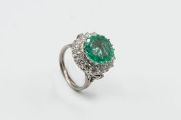 AN EMERALD AND DIAMOND CLUSTER RING