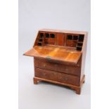 A GEORGE II FEATHER BANDED WALNUT BUREAU