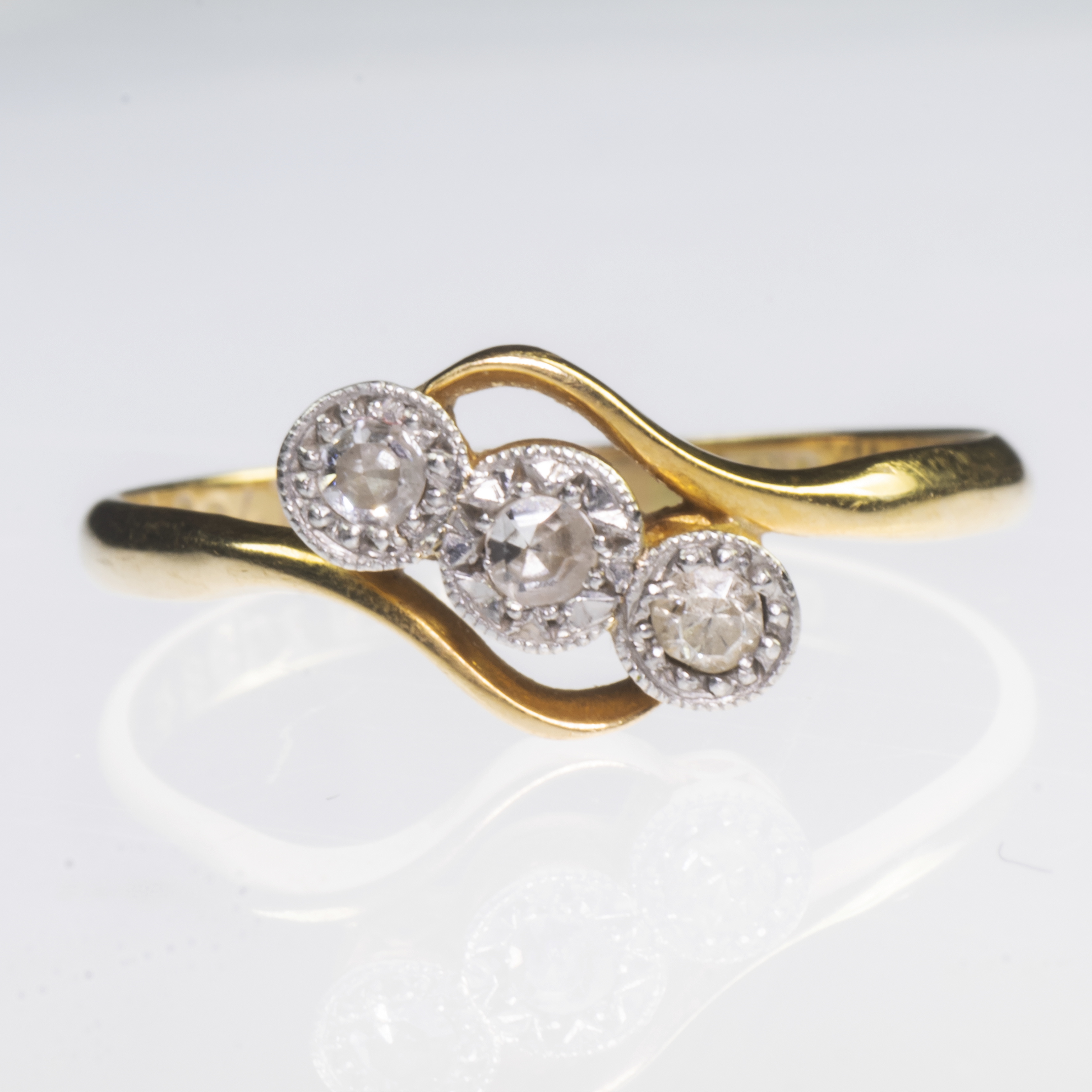 AN 18CT YELLOW GOLD AND PLATINUM DIAMOND SET CROSSOVER RING