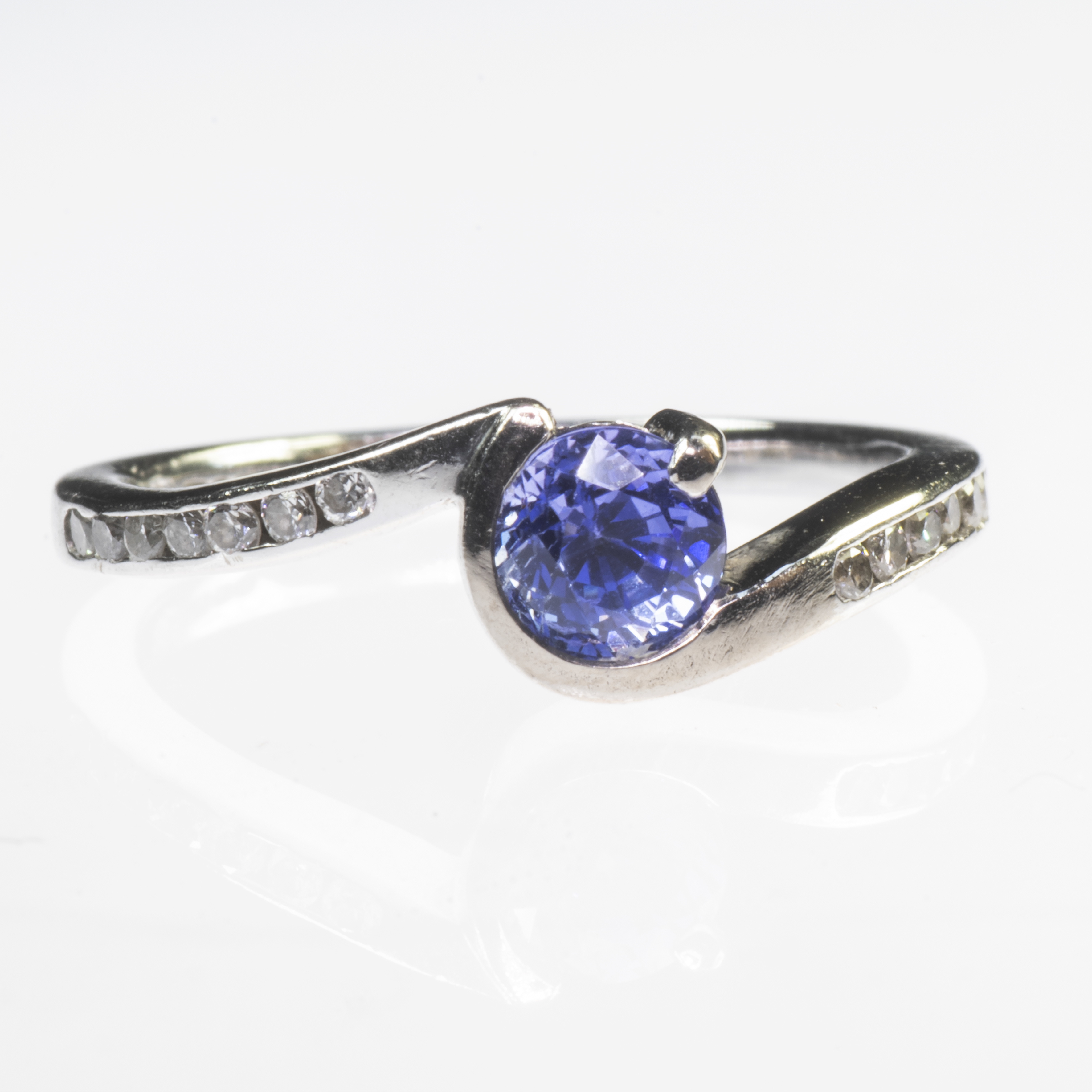 A PLATINUM SAPPHIRE AND DIAMOND CROSSOVER RING