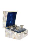 A SET OF FOUR SILVER-PLATED SCENT BOTTLES, IN A MOTHER-OF-PEARL CASKET