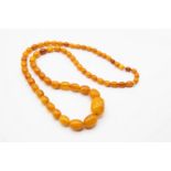 AN AMBER COLOURED BEAD NECKLACE