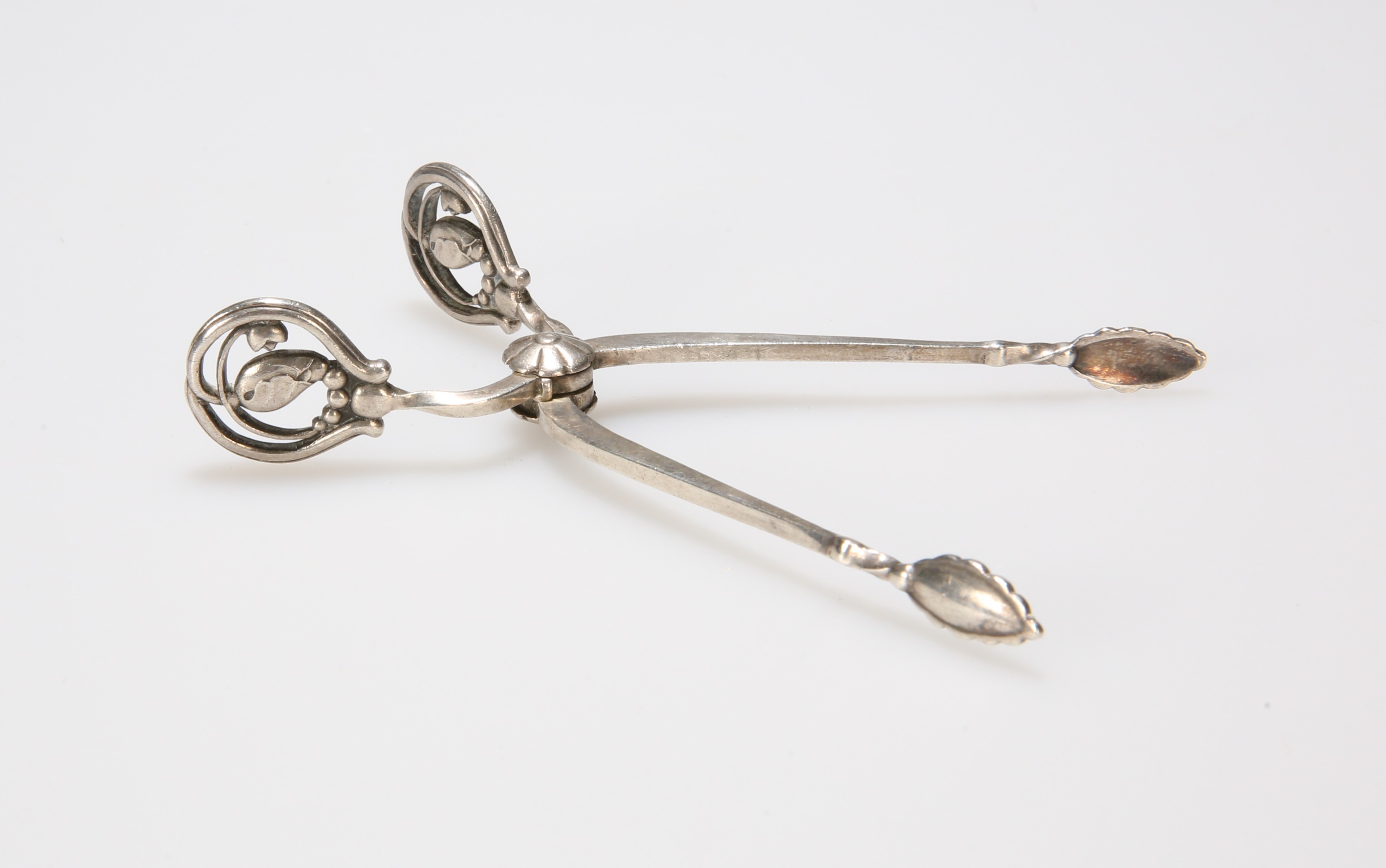 A PAIR OF DANISH SILVER SUGAR TONGS BY GEORG JENSEN