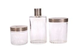 A SET OF THREE GEORGE V SILVER-TOPPED CUT GLASS DRESSING TABLE BOTTLES, HALLMARKED FOR LONDON 1924