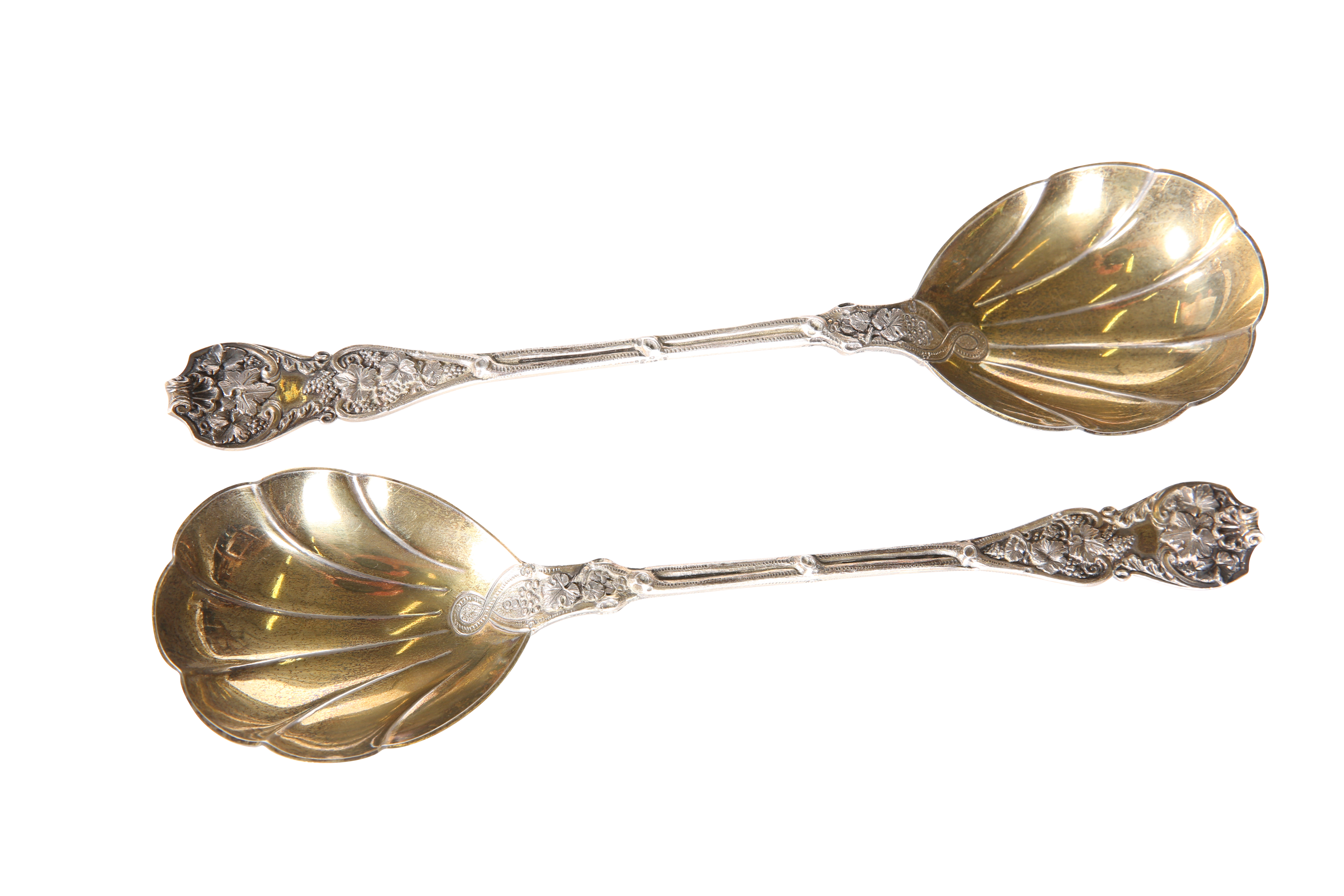 A PAIR OF LATE VICTORIAN SILVER AND SILVER-GILT FRUIT SERVING SPOONS