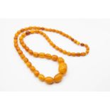 AN AMBER COLOURED BEAD NECKLACE