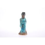 A SMALL MING BLUE GLAZED POTTERY FIGURE OF A GOD