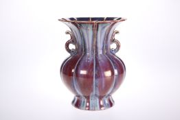 A CHINESE PORCELAIN TWIN-HANDLED VASE IN A STREAKY OX BLOOD GLAZE