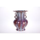 A CHINESE PORCELAIN TWIN-HANDLED VASE IN A STREAKY OX BLOOD GLAZE