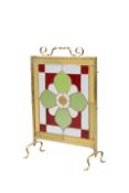 AN EDWARDIAN BRASS, LEADED AND STAINED GLASS FIRESCREEN