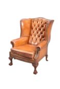 A GEORGIAN STYLE BROWN LEATHER WING CHAIR