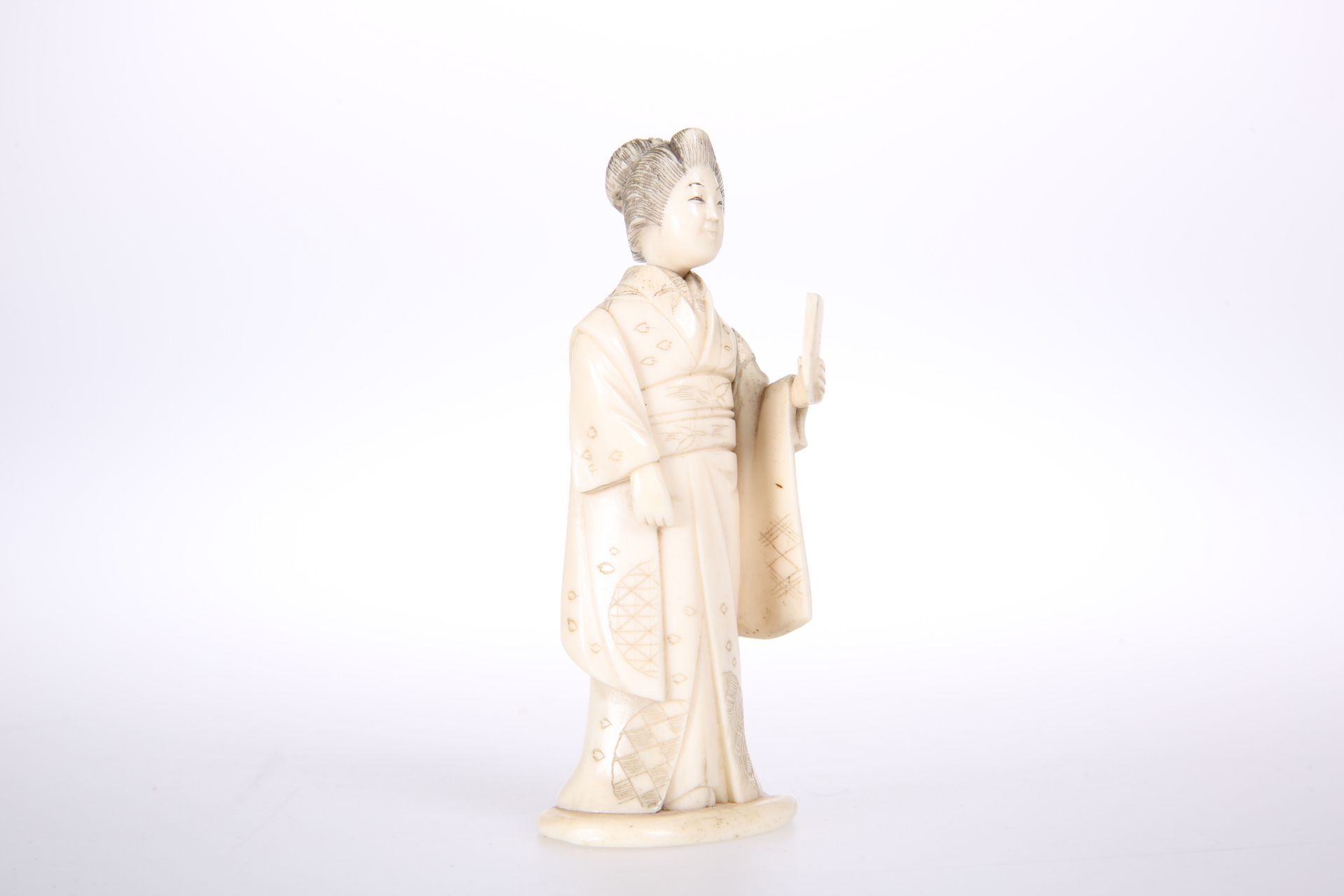 A JAPANESE CARVED IVORY FIGURAL NEEDLE CASE, MEIJI PERIOD, c. 1900