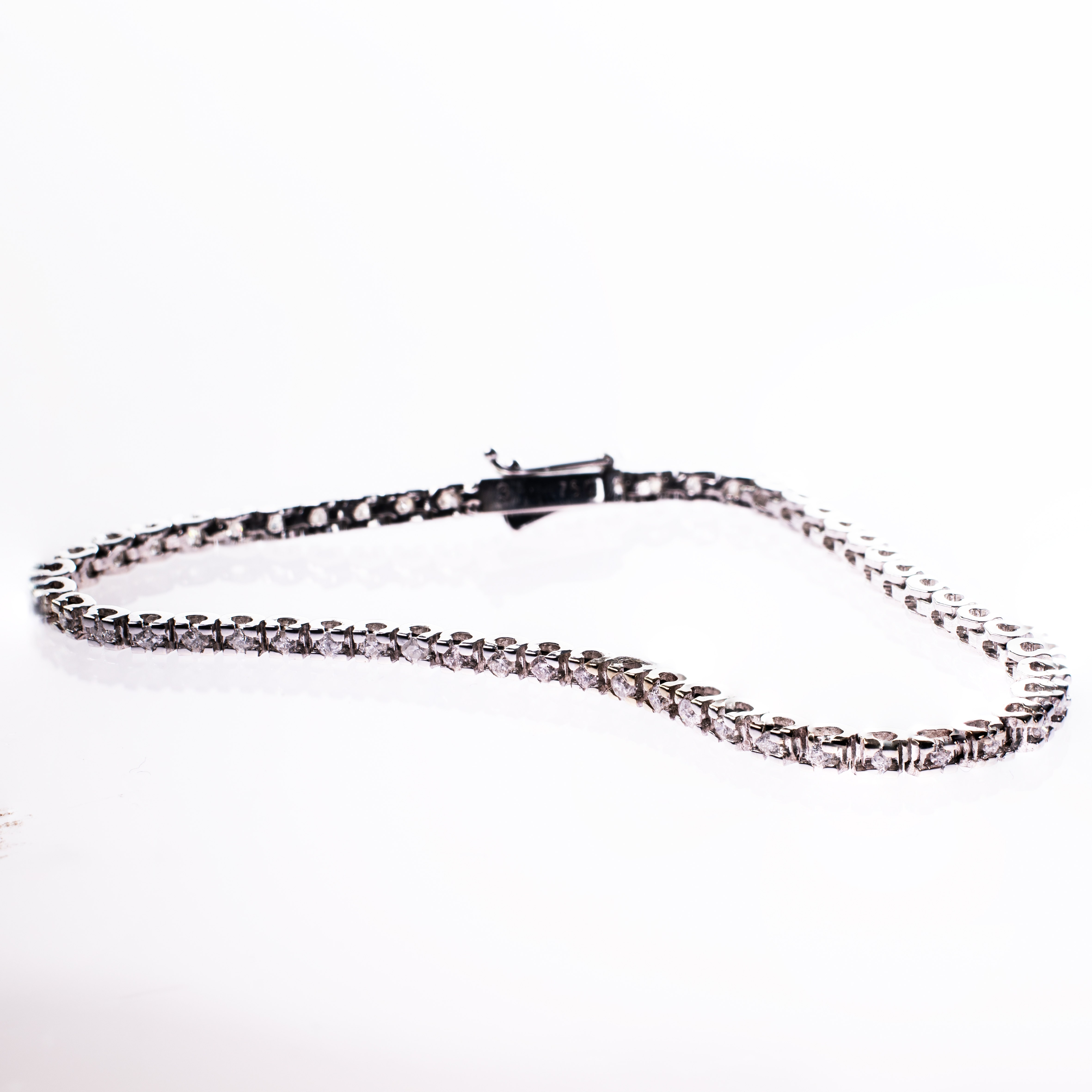 AN 18CT WHITE GOLD AND DIAMOND LINE BRACELET