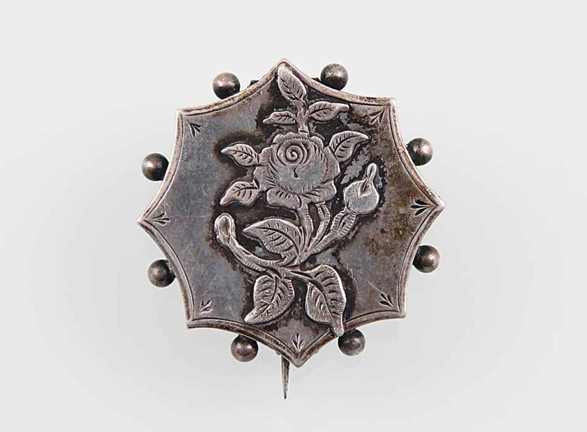 Brosche1. Hälfte 20. Jh.. Silber. Geschweifter Rand mit Granulat, feines Rosenrelief. D 3,2 cm. 4,