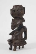 Sitzende weibliche FigurAfrika. Holz, braun-graue Patina. H 28,2 cm. Ein Fuß des Hockers fehlt.o.