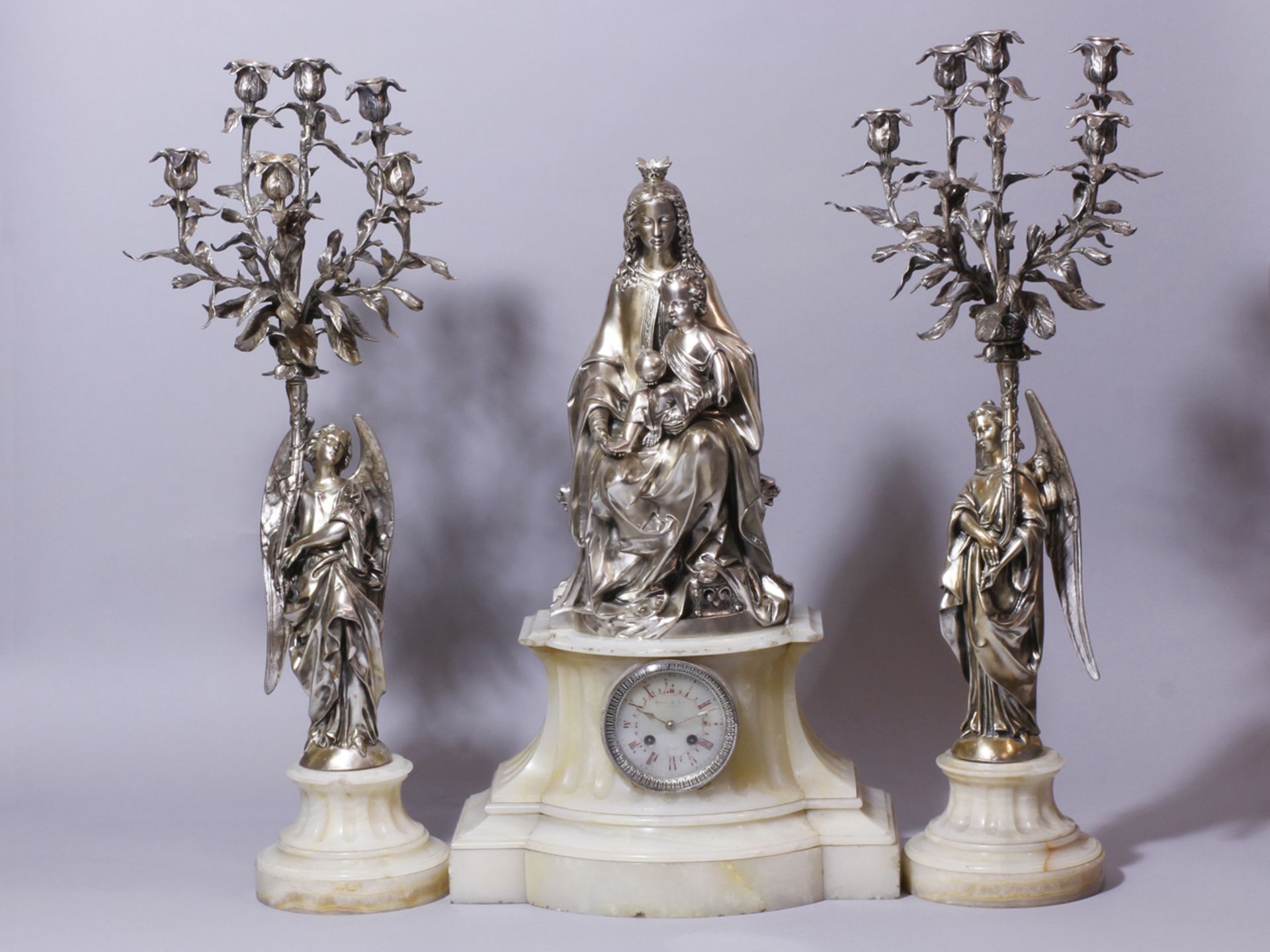 Garniture de cheminée en bronze argenté; l'élément central figurant une Vierge à [...]